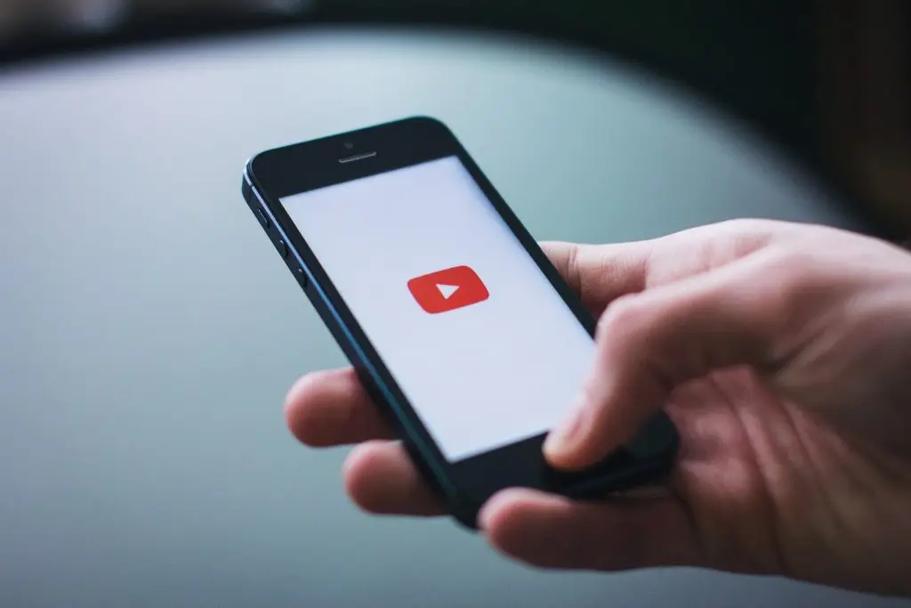 Person holding a phone checking YouTube